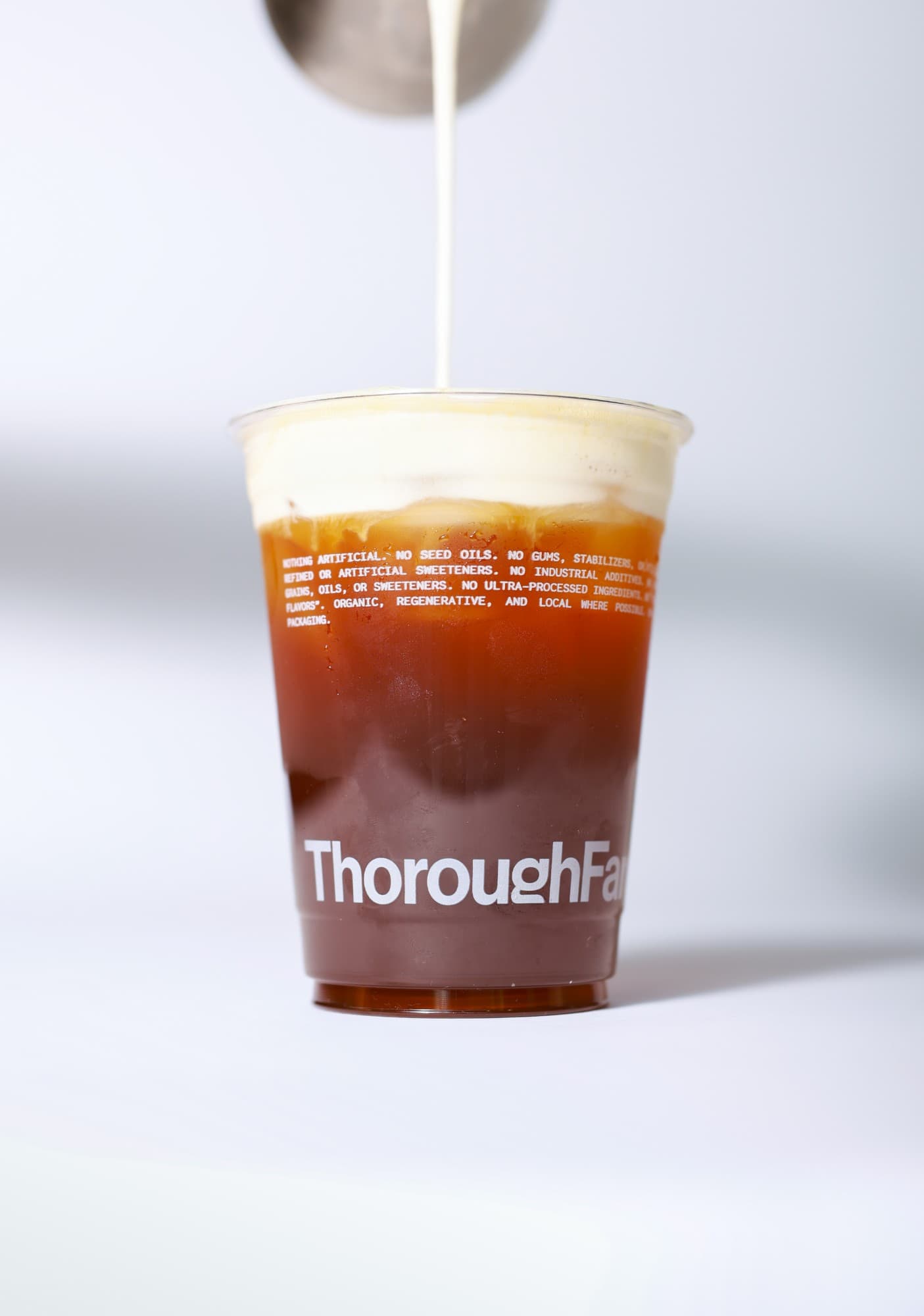 Cream pouring into a vanilla cream cold brew