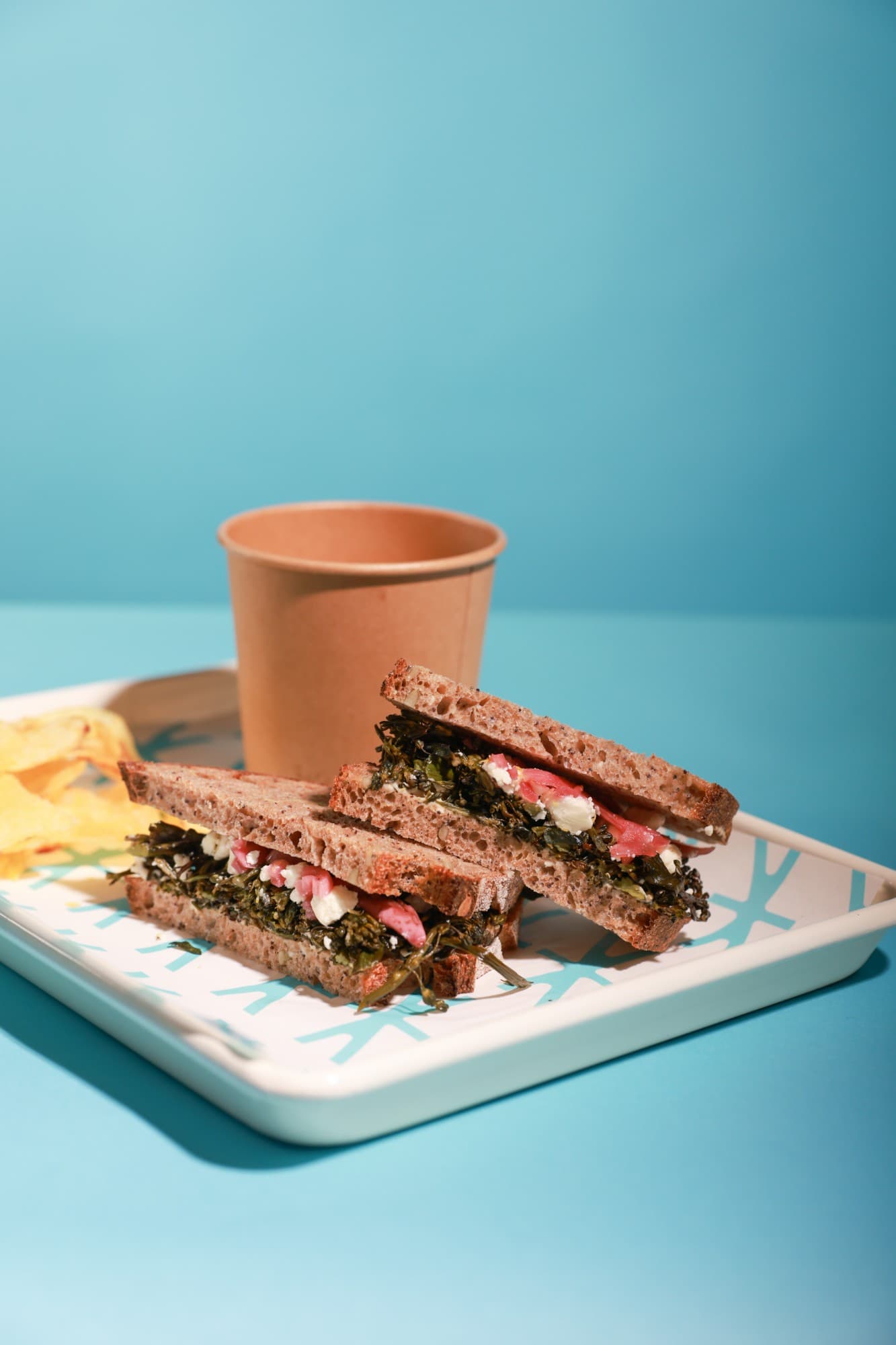 A ThoroughFare sandwich with chips and a cup on a tray