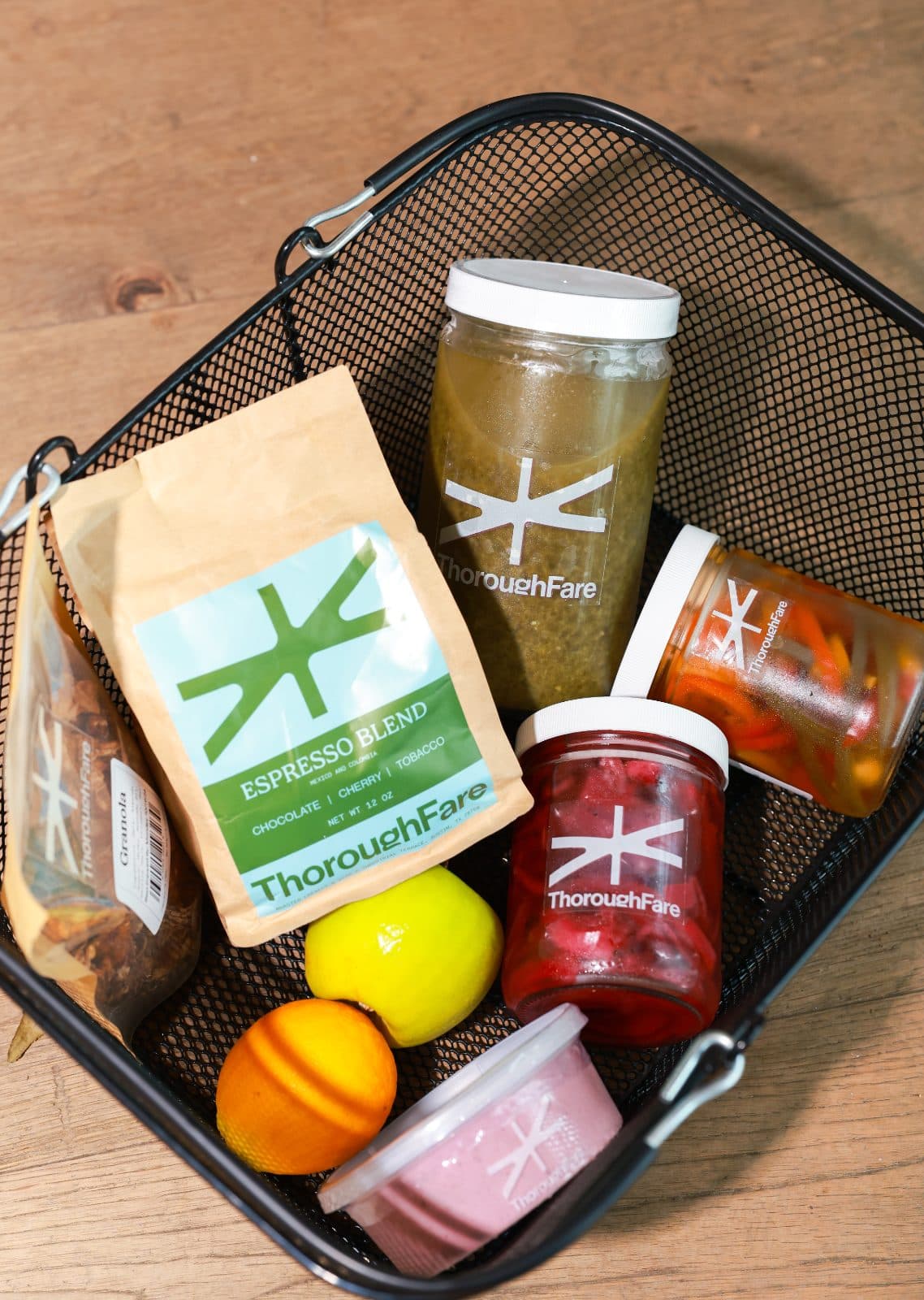 A shop basket of ThoroughFare jars, granola and a bag of Espresso Blend coffee